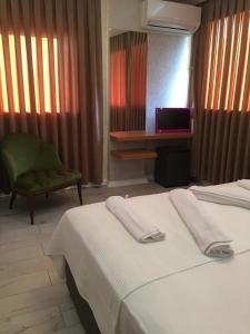 een hotelkamer met twee bedden en een stoel bij Lila Butik Hotel Dikili in Dikili