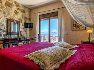 Villa Kalliani في كيساموس: غرفة نوم بسرير لحاف احمر ونافذة