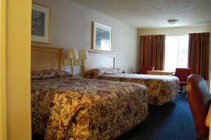 a hotel room with two beds and a window at Western Inn Lakewood in Lakewood