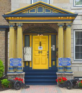 a yellow door on the front of a building at The Noble Waterfront Apartment Suites in Brockville