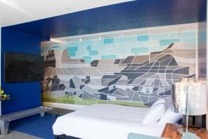 ein Schlafzimmer mit einem Wandbild aus Bergen in der Unterkunft Skyfall Guestrooms in Green River