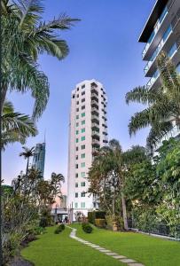 a tall white building with a park in front of it at Honeymoon Retreat in Gold Coast