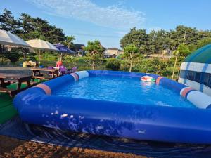 a large blue inflatable pool in a yard at Mongsanpo High Beach Pension in Taean