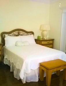 a bedroom with a white bed with a wooden headboard at The Blue Inn Family Vacation Rental in Smith Point