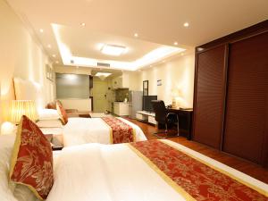 una camera d'albergo con due letti e una scrivania di Guangzhou Pengman Apartment Zhengjia Huanshi Branch a Canton Altre 37 foto
