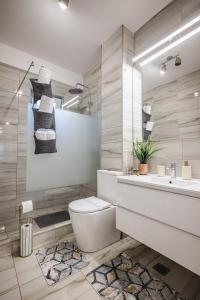 a bathroom with a toilet and a sink at Luxury Designer Apartment - Romanescu Park in Craiova