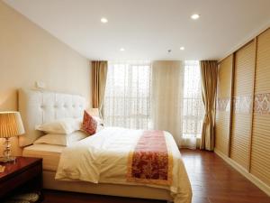 una camera da letto con un letto grande e finestre di Guangzhou Pengman Apartment Zhengjia Huanshi Branch a Canton