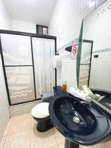 a bathroom with a black sink and a toilet at Apartamento en San Cristóbal con 2 habitaciones, 6 camas, sala, comedor, cocina, balcón privado, terraza con vista al mar, lavadora, internet satelital, cerca de bares y restaurantes - Sol y Mar, Galápagos Home in Puerto Baquerizo Moreno +48 photos
