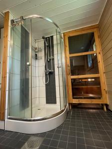 una ducha con puerta de cristal en un baño en Mörrimöykky Iso-Syöte hirsimökki, en Pudasjärvi 19 fotos más