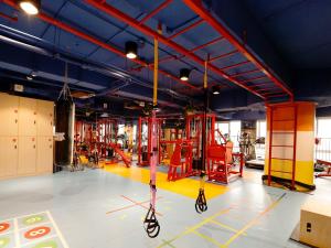 una palestra con attrezzature rosse e gialle in una stanza di Guangzhou Pengman Apartment Zhengjia Huanshi Branch a Canton