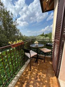 a patio with a table and chairs on a balcony at Casa Carolina Vista Lago e Giardino Privato a San Gimignano in San Gimignano