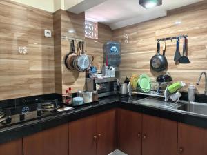 a kitchen with a sink and a counter with pots and pans at Ayuna Guest House in Darmasaba