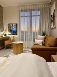 ein Wohnzimmer mit Couch und großem Fenster in der Unterkunft Modern Studio in Menlyn Maine in Pretoria