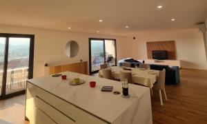 a room with tables and chairs and a living room at Sisters Apartamento -200m2 centre ville in Ponte da Barca