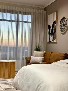 ein Schlafzimmer mit einem Bett und einer Couch und einem Fenster in der Unterkunft Modern Studio in Menlyn Maine in Pretoria + 23 Fotos
