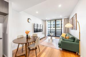 un soggiorno con tavolo e divano verde di Central Comfort ,CBD 2BR w Free Parking, Wifi a Braddon