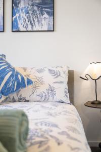 un letto con cuscini blu e bianchi e una lampada di Central Comfort ,CBD 2BR w Free Parking, Wifi a Braddon