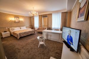 Habitación de hotel con cama y TV de pantalla plana. en Hotel Orto Asia en Osh