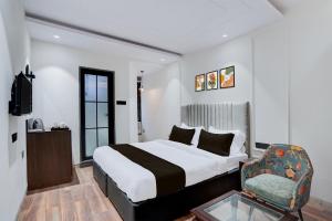 a hotel room with a bed and a chair at Super Townhouse Karol Bagh Formerly Hotel Unistar in New Delhi