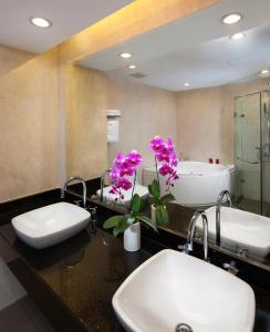 a bathroom with two sinks and a bath tub at Elegant Suites Westlake in Hanoi