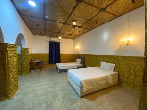a bedroom with two beds and a table in a room at Le Hotel Hotel Phnom Penh in Phnom Penh +49 photos