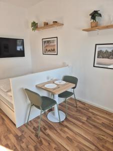 a dining room with a table and two chairs at Studio 2 - Apartments am Schloss in Oberschleißheim