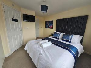 a bedroom with a large bed with blue and white pillows at Durham city free onsite parking in Sheepscar