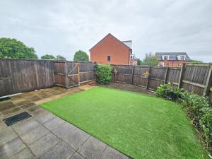 a small backyard with a fence and green grass at Durham city free onsite parking in Sheepscar