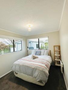 a bedroom with a bed and two windows at Waiwhetū 3 bedrooms house Retreat in Lower Hutt +9 photos