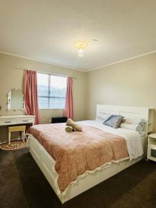 a bedroom with a large bed with a desk and a window at Waiwhetū 3 bedrooms house Retreat in Lower Hutt