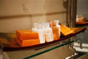 a shelf with bottles of honey and a box on it at Mirth Sathorn Hotel in Bangkok