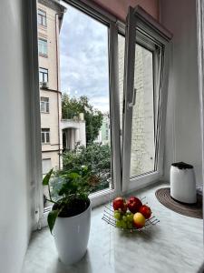Два Кроки до Хрещатика Історичний Центр Укриття Є في كييف: نافذة مفتوحة مع وعاء من الفاكهة على حافة النافذة