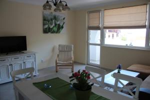 a living room with a table and chairs and a television at Karchevi Apartment in Sveti Vlas