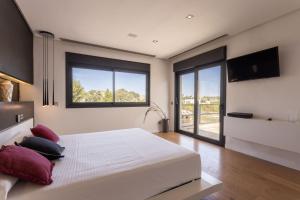 a bedroom with a large white bed and a flat screen tv at Casa Joan Only Familes con Piscina Privada in Llubí +29 photos