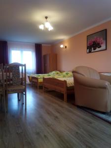 a bedroom with a bed and a couch and a chair at Pokoje Pod Łukami in Solina