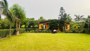 two people sitting in a yard in front of a house at The galilee farmhouse in Noida +17 photos