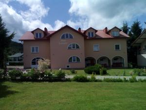a large house with a lawn in front of it at Pokoje Pod Łukami in Solina