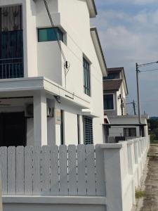 a white fence in front of a white house at The Cermai Homestay in Sungai Buluh