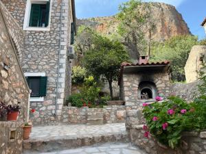 a stone building with a courtyard with flowers at Sunshine 1 in Leonidio