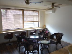 a waiting room with chairs and tables and a window at Guesthouse WIND VILLA Kyoto in Kyoto