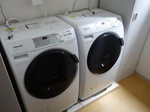 two washing machines sitting next to each other in a room at Guesthouse WIND VILLA Kyoto in Kyoto
