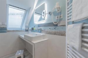 a white bathroom with a sink and a window at Best Western Plus Theodor Storm Hotel in Husum +120 photos