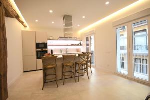 a kitchen with a counter and some stools in a room at Sotileza Select Santander in Santander