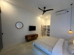 Un dormitorio con una cama y un ventilador de techo. en Radin Group 6, en Kuta Lombok