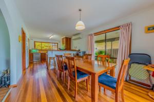 Una cocina y un comedor con mesa y sillas de madera. en Driftwood On Anderson - Free Wifi, en Inverloch