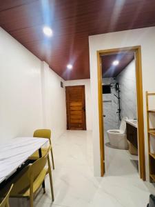 a dining room with a table and a bathroom at Gavin's Cozy Place Wifi Petfriendly Karaoke Parking in Imus