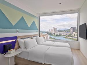 老街市Tru by Hilton Lao Cai City Riverside的卧室里有一张白色的床和一扇大窗户 更多22张照片
