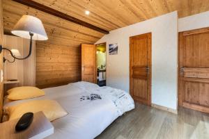 un letto in una stanza con soffitto in legno di Chalet Snow Pearl a Les Menuires