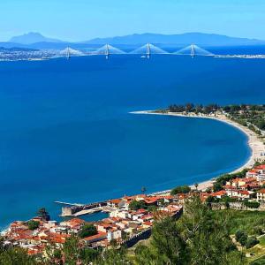 a view of a beach with a bridge in the background at NAFPAKTOS APARTMENT, STUDIOS AND ROOMS iN PORT in Nafpaktos