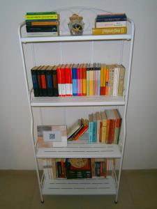 a white book shelf filled with books at Bed & Breakfast Pansion Rade in Pirovac